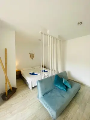 a bedroom with a bed and a blue couch at Magnolia Studio 303 in Lagos