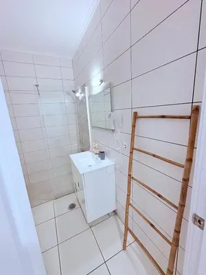 a white bathroom with a sink and a mirror at Magnolia Studio 303 in Lagos