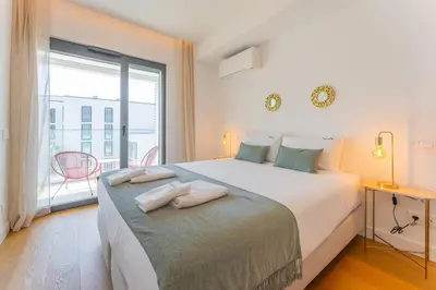 a bedroom with a large bed with a large window at FLH Funchal Seaside at Acqua Residences in Funchal
