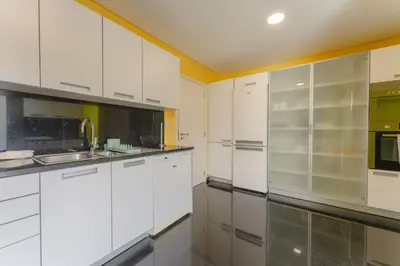 a white kitchen with white cabinets and a sink at FLH Funchal City View at Quinta da Nogueira Residence in Funchal