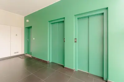 a row of green doors in an empty room at FLH Funchal City View at Quinta da Nogueira Residence in Funchal