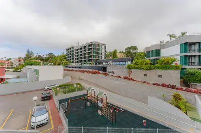 a building with a parking lot with a car on it at FLH Funchal City View at Quinta da Nogueira Residence in Funchal