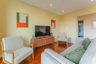 a living room with a tv and two chairs at FLH Funchal City View at Quinta da Nogueira Residence in Funchal