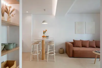 a living room and kitchen with a couch and a table at In Funchal city centre - AL'gria II in Funchal