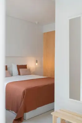 a bedroom with a bed with a orange blanket at In Funchal city centre - AL'gria II in Funchal