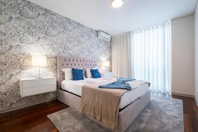 a bedroom with a large bed with blue pillows at Lux City Center Apart-Free Park EU in Funchal