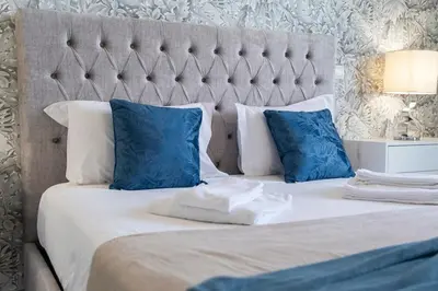 a bedroom with a bed with blue and white pillows at Lux City Center Apart-Free Park EU in Funchal