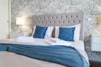 a bedroom with a large bed with blue pillows at Lux City Center Apart-Free Park EU in Funchal