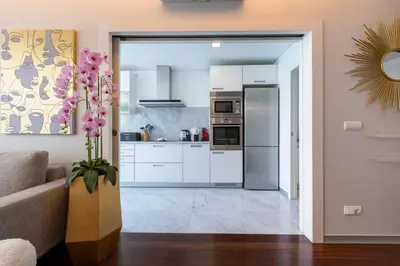 a kitchen with white cabinets and a stainless steel refrigerator at Lux City Center Apart-Free Park EU in Funchal