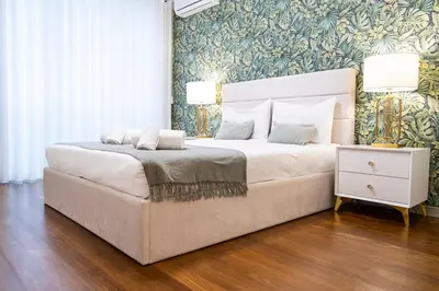 a bedroom with a large white bed and a floral wallpaper at Lux City center apartments EX in Funchal