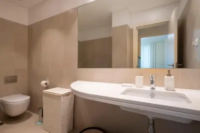 a bathroom with a sink and a toilet and a mirror at Lux City center apartments EX in Funchal