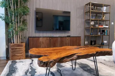 a large wooden table in a room with a tv at Lux City center apartments EX in Funchal