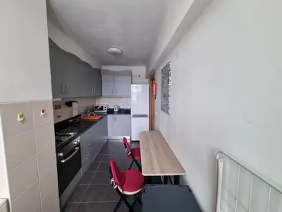 a small kitchen with a wooden table and red chairs at Blue Sky by Susys Holidays in Funchal