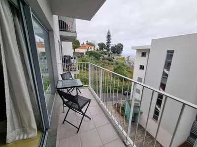 a balcony with a chair and a view of a city at Blue Sky by Susys Holidays in Funchal