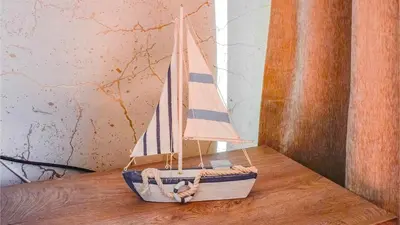 a small wooden toy boat sitting on a wooden table at By the Sea VI - Marina in Funchal