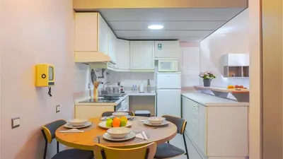 a small kitchen with a wooden table and chairs at By the Sea VI - Marina in Funchal