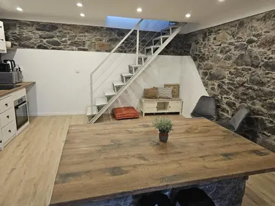a kitchen with a wooden table and a staircase at Villa Júlia, Mountain retreat in Santa Cruz