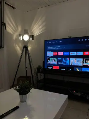 a large screen television with a light on a tripod at Santo Antonio 2 Schlafzimmer Apartment in Funchal