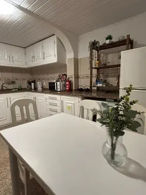 a kitchen with a table with a vase of flowers on it at Santo Antonio 2 Schlafzimmer Apartment in Funchal