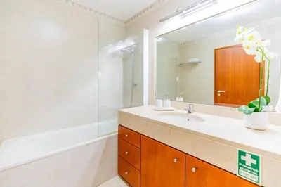 a bathroom with a sink and a shower and a mirror at Ivory Breeze by Elysian in Funchal