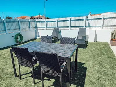 a table and chairs on a patio with the ocean at Villa Victoria, Tonel, Sagres in Sagres
