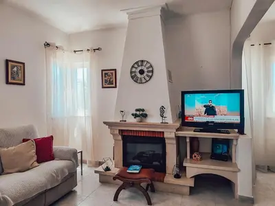a living room with a tv and a fireplace at Villa Victoria, Tonel, Sagres in Sagres