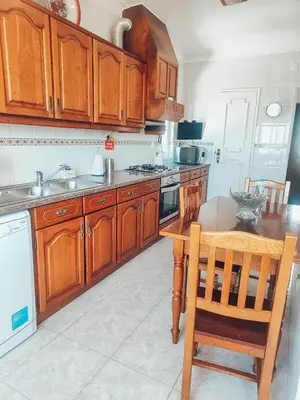a kitchen with wooden cabinets and a wooden table at Villa Victoria, Tonel, Sagres in Sagres