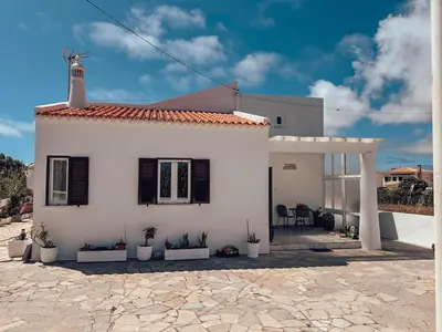 a white house with black shutters and potted plants at Villa Victoria, Tonel, Sagres in Sagres