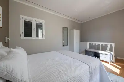 a white bedroom with a bed and a window at Madeira Loft by Mathias in Funchal