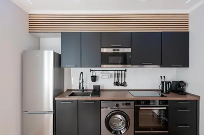 a kitchen with black cabinets and a washer at Madeira Loft by Mathias in Funchal