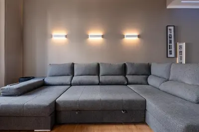 a couch in a living room with lights on the wall at Madeira Loft by Mathias in Funchal