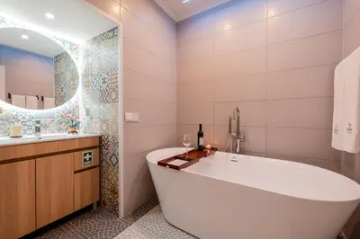 a bath tub in a bathroom with a sink and a mirror at Madeira Loft by Mathias in Funchal