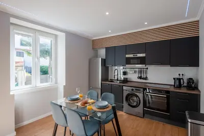 a kitchen with a glass table with blue chairs at Madeira Loft by Mathias in Funchal