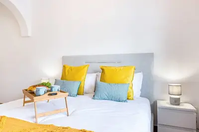 a bedroom with a bed with yellow and blue pillows at Crab House 01 by GALMI in Machico