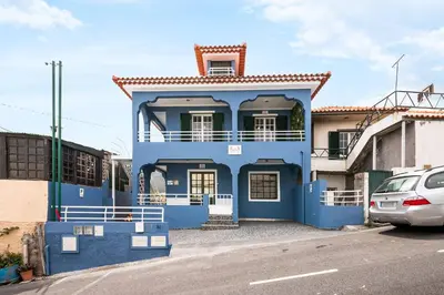a blue house with a car parked in front of it at Crab House 01 by GALMI in Machico