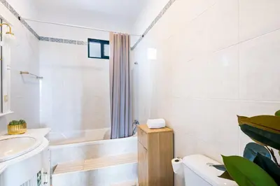 a white bathroom with a tub and a sink at Crab House 02 by GALMI in Machico