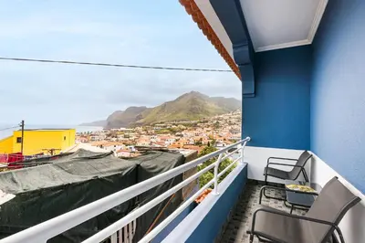 a balcony with chairs and a view of a city at Crab House 02 by GALMI in Machico