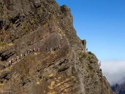a group of people walking up the side of a mountain at Villa Getaway in Santo António da Serra in Santo da Serra