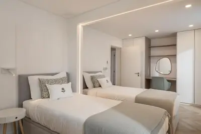two beds in a hotel room with a mirror at Casa Branca 36 by An Island Apart in Funchal
