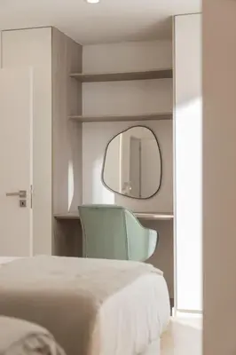 a bedroom with a green chair and a mirror at Casa Branca 36 by An Island Apart in Funchal
