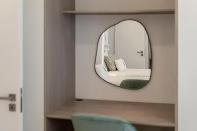 a mirror in a room with a bed and a chair at Casa Branca 36 by An Island Apart in Funchal