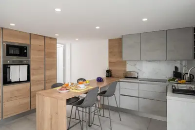 a kitchen with a wooden table and some chairs at Casa Branca 36 by An Island Apart in Funchal