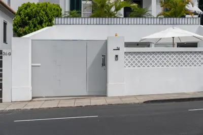 a white fence with an open door and an umbrella at Casa Branca 36 by An Island Apart in Funchal