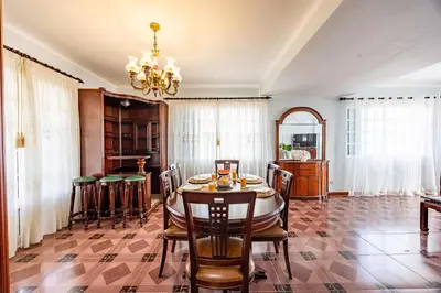 a dining room with a table and chairs and a chandelier at Ocean Side Vista by YOUR KEY in Funchal