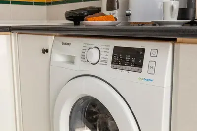a washing machine with a counter on top of it at Topside Luz Guesthouse in Luz