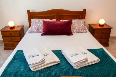 a bedroom with a bed with two towels on it at Topside Luz Guesthouse in Luz