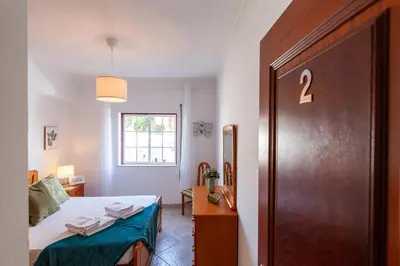 a bedroom with a bed and a door with the number two at Topside Luz Guesthouse in Luz