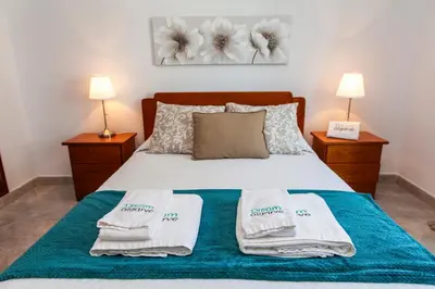 a bedroom with a bed with towels on it at Topside Luz Guesthouse in Luz