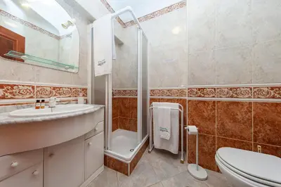 a bathroom with a shower and a sink and a toilet at Topside Luz Guesthouse in Luz