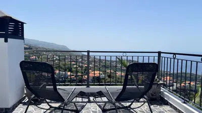 two chairs sitting on top of a balcony with a view at Golden Horizon House By Sam Houses in Ponta do Sol